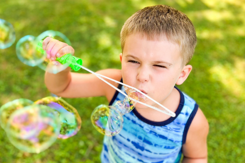 boy blowing bubbles with a bubble wand