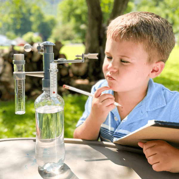 Child using a weather STEM kit to track temperature and cloud types