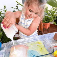 Preschooler creating a rainbow volcano experiment with STEM weather kit