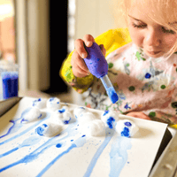 Preschooler creating a rainbow volcano experiment with STEM weather kit