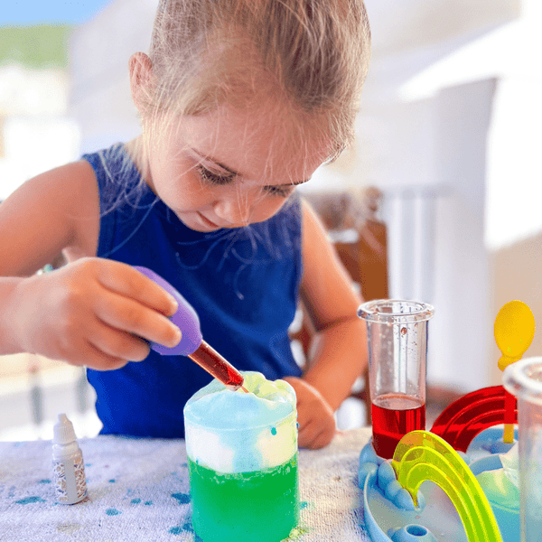 Preschooler creating a rainbow volcano experiment with STEM weather kit