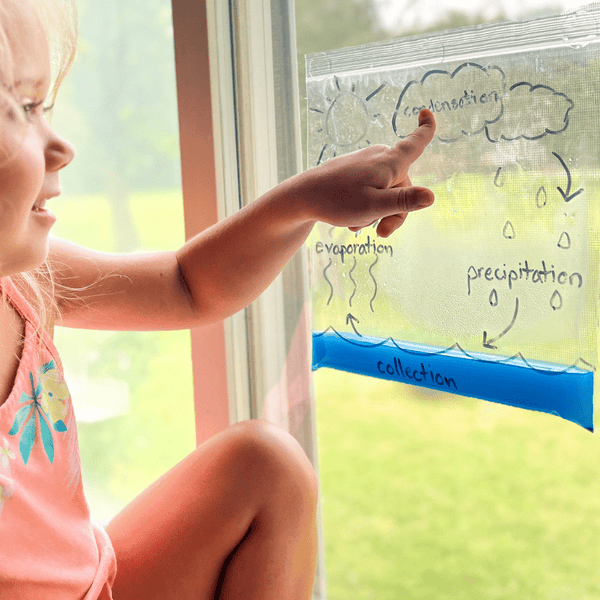 Preschooler creating a rainbow volcano experiment with STEM weather kit