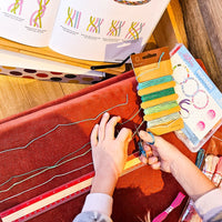 Child using a DIY bracelet craft kit to create handmade jewelry