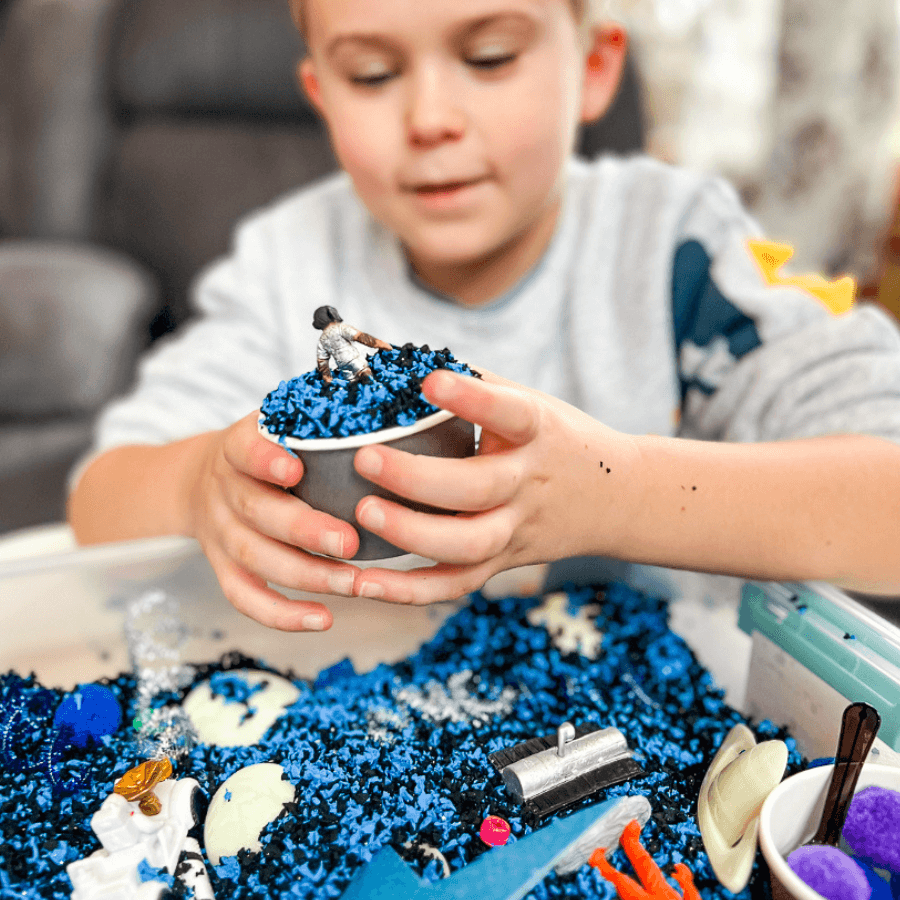 Sensory play bin with Playfoam, glow-in-the-dark planets, and Safari LTD Space TOOB.